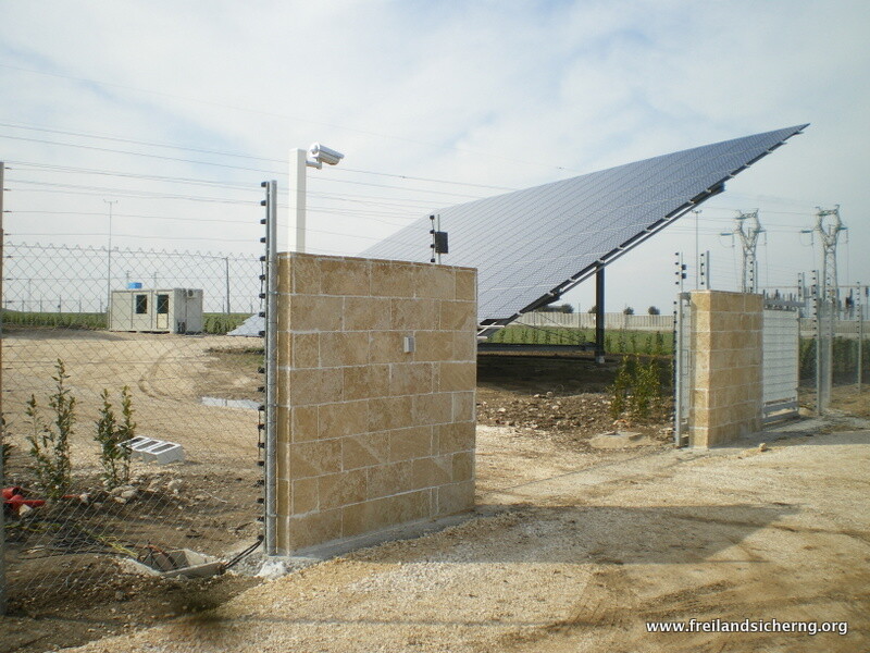 Stromzaunsystem an einer Torzufahrt aus Natursteinmauern bei einer Solaranlage